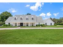 Charming single-story home with a well manicured lawn, brick driveway, and welcoming entrance, nestled beneath a picturesque sky at 2395 Campbell Rd, Clearwater, FL 33765