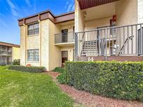 Charming condo building featuring well-maintained landscaping and two-story facade at 2400 Winding Creek Blvd # 14-201, Clearwater, FL 33761