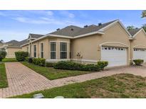 Charming single-story home with a brick walkway, manicured landscaping, and an attached two-car garage at 2616 Tottenham Dr, New Port Richey, FL 34655
