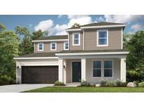 A charming two-story home featuring a front-entry two-car garage, a welcoming front porch, and tidy landscaping at 33306 Castaway Loop, Wesley Chapel, FL 33543
