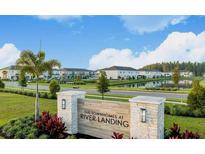Scenic view of The Townhomes at River Landing entrance with lush landscaping and view of the townhome community at 34234 Polacca Ln, Wesley Chapel, FL 33543