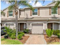 Charming townhouse featuring a one car garage, a front yard with lush green bushes and beautiful landscaping at 3901 Silverlake Way, Wesley Chapel, FL 33544