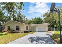 Charming single-story home with a well-maintained lawn, a one-car garage, and a long driveway at 39721 Meadowood Loop, Zephyrhills, FL 33542