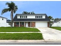 Charming two-story home with a well-manicured lawn, brick facade, and a convenient two-car garage at 4725 Soapstone Dr, Tampa, FL 33615