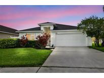 Charming single-Gathering home with well-maintained lawn and landscaped front yard, featuring a two-car garage at 630 Lake Cypress Cir, Oldsmar, FL 34677
