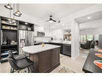 Bright kitchen featuring stainless steel appliances, a stylish island, and modern black and white cabinetry at 6330 99Th N Way # 14B, Seminole, FL 33708