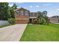Charming two-story home with a well-manicured lawn and a two car garage at 10512 Scenic Hollow Dr, Riverview, FL 33578