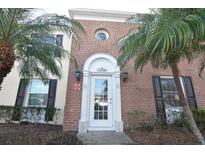 Charming brick home with a white front door framed by palm trees at 13758 Orange Sunset Dr # 202, Tampa, FL 33618