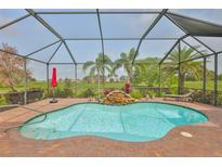 Inviting screened-in pool with waterfall feature and lush landscaping, perfect for relaxation and outdoor enjoyment at 1723 Pacific Dunes Dr, Sun City Center, FL 33573
