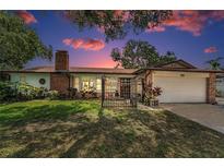 Charming brick home with a well-manicured lawn, gated entry, and attached two-car garage at 1899 Oak Park S Dr, Clearwater, FL 33764