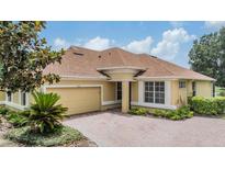 Charming home with a brick driveway, mature landscaping and a two car garage at 27427 Mistflower Dr, Wesley Chapel, FL 33544
