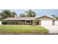 Charming single-story home featuring a brick and vinyl facade with a two-car garage and manicured landscaping at 3235 Walnut Ne St, St Petersburg, FL 33704