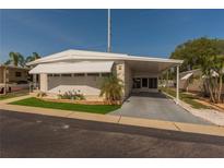 Charming single-story home featuring a carport, awnings, and well-maintained landscaping at 3301 Alt 19 # 819, Palm Harbor, FL 34683