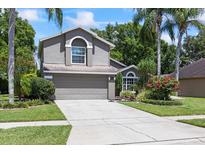 Charming two-story home with a well-manicured lawn and a two car garage at 4047 Eagle Cove West Dr, Palm Harbor, FL 34685