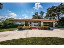 Charming home with a red tile roof, lush landscaping, and a well-maintained front yard at 431 Windward Psge, Clearwater Beach, FL 33767