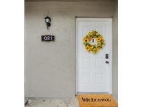 Charming white front door adorned with a sunflower wreath and a welcoming doormat at 4513 S Oak Dr # Q21, Tampa, FL 33611