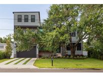 Striking modern home with metal accents, dark trim, a well-manicured lawn and mature tree at 4806 W Euclid Ave, Tampa, FL 33629
