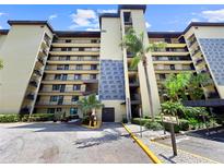 Multi-story condo building with balconies, tropical landscaping, and convenient elevator access at 650 Island Way # 408, Clearwater Beach, FL 33767
