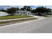 Charming single-story home with a well-manicured lawn and a lovely blue front door at 7536 38Th N Ave, St Petersburg, FL 33710