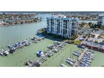 Stunning aerial view of waterfront condo building and private marina with boats docked in slips on a sunny day at 9525 Blind Pass Rd # 505, St Pete Beach, FL 33706