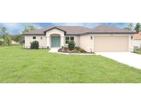 Charming single-story home with a well-manicured lawn and a welcoming light-blue front door at 13098 Convent Garden Rd, Brooksville, FL 34614