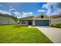 Charming single-story home featuring a manicured lawn and a two-car garage at 16433 66Th E Ln, Parrish, FL 34219