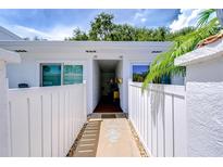 Inviting condo exterior with white fence, walkway, and lush tropical landscaping at 1655 S Highland Ave # B118, Clearwater, FL 33756