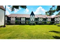 Charming Tudor-style condo building with well-maintained lawn and intricate black and white facade details at 230 N Bayshore Blvd # 103, Clearwater, FL 33759