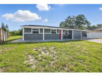 Charming single-story home with a well-maintained lawn and a striking red front door at 2419 Wishing Well Way, Tampa, FL 33619