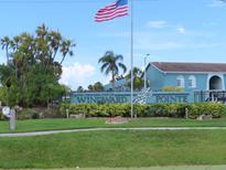 Welcome to Windward Pointe, featuring lush landscaping and a beautiful condominium community with an American flag waving above at 364 115Th N Ave # 1, St Petersburg, FL 33716