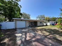 Charming single-story home with a driveway, attached garage, and well-maintained front lawn at 422 Crosswinds Dr, Palm Harbor, FL 34683