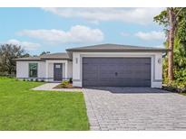 Charming single-story home featuring a gray two-car garage, gray door and meticulously maintained landscaping at 4625 Vernell St, North Port, FL 34291