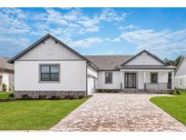 Charming single-Gathering home featuring a brick driveway, landscaped front yard, and covered porch at 4773 Hickory Oak Dr, Brooksville, FL 34601