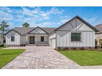 Stunning single-story home featuring a brick driveway, gray accents, and professionally landscaped front yard at 4799 Hickory Oak Loop, Brooksville, FL 34601