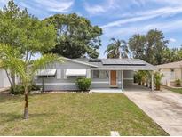 Charming single-story home featuring solar panels, awning-covered windows, and a convenient covered carport at 6497 43Rd N Ave, Kenneth City, FL 33709