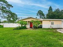 Charming single-story home featuring a well-manicured lawn and vibrant landscaping at 6706 S Trask St, Tampa, FL 33616