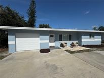 Charming single-story home with a well-manicured lawn, attached garage and cozy patio seating area at 814 19Th Sw St, Largo, FL 33770