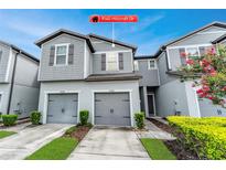 Charming gray two-story home with attached two-car garage and landscaped yard at 9140 Hillcroft Dr, Riverview, FL 33578