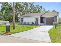 Charming single-story home featuring a well-manicured lawn, driveway, and stone accents at 9511 N Hyaleah Rd, Tampa, FL 33617