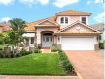 Charming two-story home featuring a red tile roof, manicured lawn, and a welcoming front patio at 9800 Sago Point Dr, Seminole, FL 33777