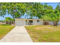 Charming single-story home featuring a well-maintained front yard and a concrete driveway leading to a single-car garage at 10599 111Th N Ave, Largo, FL 33773