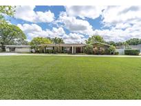 Charming single-story home featuring a huge front lawn, mature trees and attractive landscaping at 10611 131St St, Largo, FL 33774