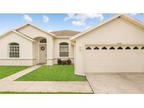 Charming single-story home with a well-manicured lawn, arched entryway, and attached two car garage at 10621 Ribbon Fern Way Way, Land O Lakes, FL 34638