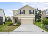 Charming two-story home featuring a two-car garage, stone accents, and a well-maintained lawn at 1680 Hazy Sea Dr, Plant City, FL 33565