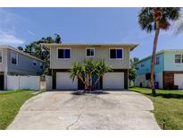 Two-story home featuring a spacious driveway, and complemented by a palm tree at 1858 Michigan Ne Ave, St Petersburg, FL 33703