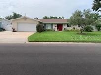 Charming single-story home with a well-maintained lawn, a two-car garage, and a welcoming red front door at 6474 29Th N Ave, St Petersburg, FL 33710