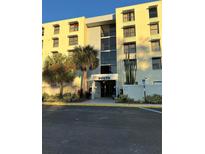 Exterior view of a multi-story condo building featuring well-maintained landscaping and clearly marked entrance at 701 S Madison Ave # 410, Clearwater, FL 33756