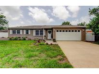 Charming single-story home with a well-maintained lawn, tidy landscaping, and a white two car garage door at 755 Green Valley Rd, Palm Harbor, FL 34683
