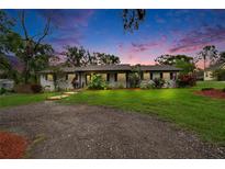 Charming single-story home with white brick, manicured lawn, and lush landscaping with a stone walkway at 8222 Valrie Ln, Riverview, FL 33569