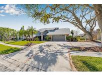 Charming home featuring mature landscaping, a brick-lined driveway, and a two-car garage at 9011 Baywood Park Dr, Seminole, FL 33777
